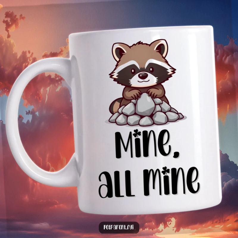 Funny raccoon mug showing a protective raccoon character guarding a small pile of shiny rocks, symbolizing possessiveness and charm.